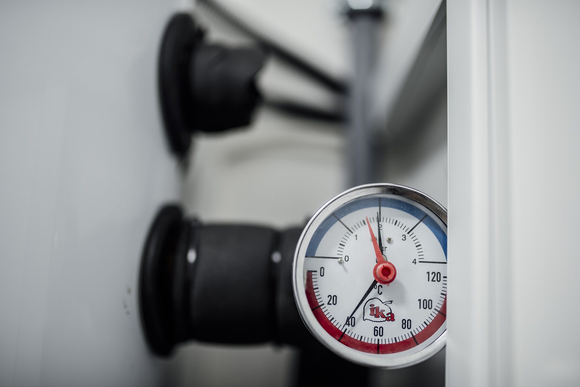 Thermomanomètre d'une installation de chauffage, aiguille rouge autour de 1 bar, manchons isolants noirs en arrière-plan